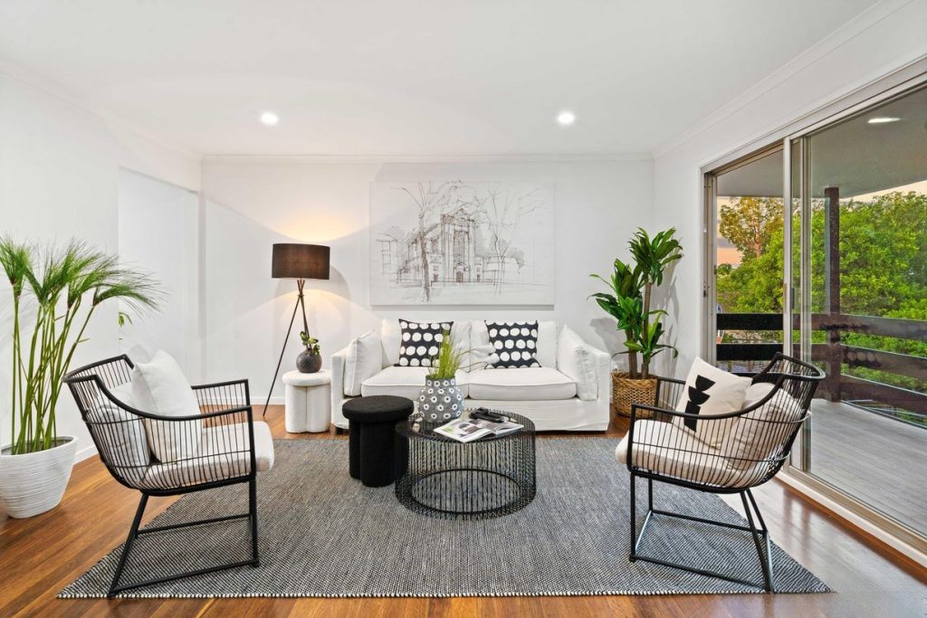 Sophisticated living space with neutral palette and open balcony access