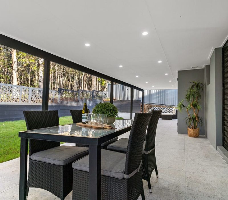 Outdoor area with green lawn and black privacy screens