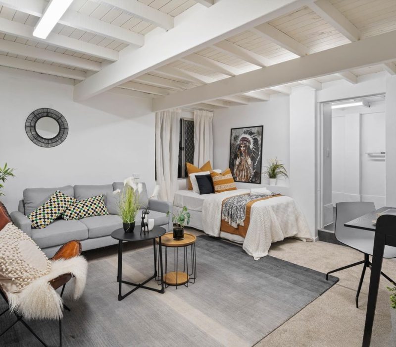 Multi-use living area with exposed ceiling beams and relaxed styling