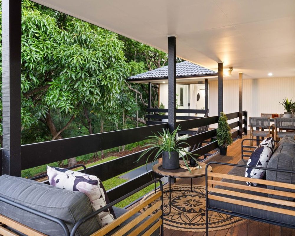 Elevated deck with outdoor seating and dining overlooking greenery