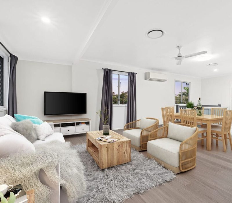 Open-plan living and dining room with timber floors, neutral walls, and modern ceiling finishes